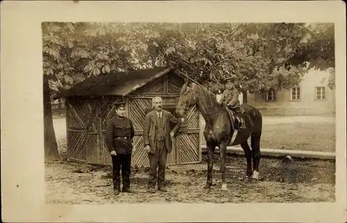 Foto Ak Hohenau, Männer, Kind auf einem Pferd, Holzhütte, 1917