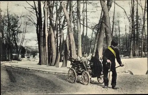 Ak Alter Mann zieht Karren mit Holz, Holzstücke