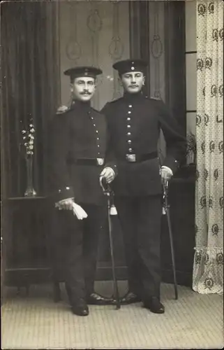 Foto Ak Zwei Deutsche Soldaten im Atelier stehend, Kaiserzeit, Säbel