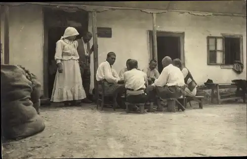 Foto Ak Rumänien ?, Arbeiter beim Mittag vor einem Gebäude