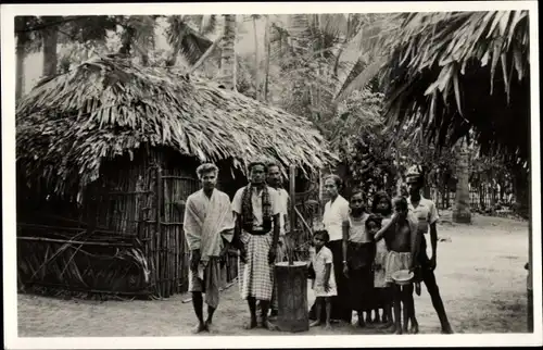 Ak Indonesien, Ortsanwohner vor einem Haus, Einheimische, Haus mit Strohdach