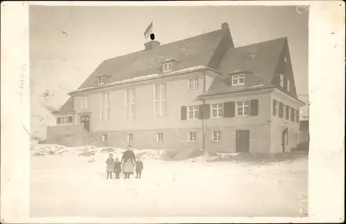 Foto Ak Frau mit drei Kindern vor Wohnhaus, Winter