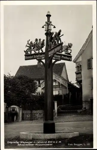 Ak Lenzkirch im Schwarzwald, Wegweiser Schaffhausen, Freiburg, Stuttgart, Holzschnitzerei