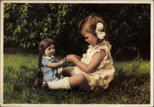 Ak Kleines Mädchen sitzt mit ihrer Puppe auf einer Wiese