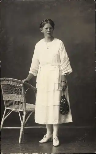 Foto Ak Portrait einer Frau im weißen Kleid, Standportrait, Korbstuhl, Tasche