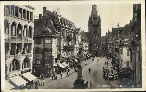 Ak Freiburg im Breisgau, Straßenpartie, Stadttor, Läden, Denkmal