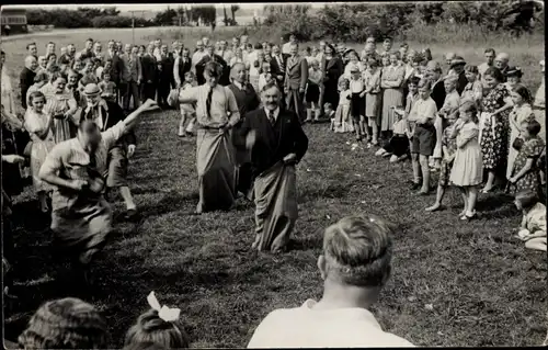 Foto Ak Männer und Frauen beim Sackhüpfen