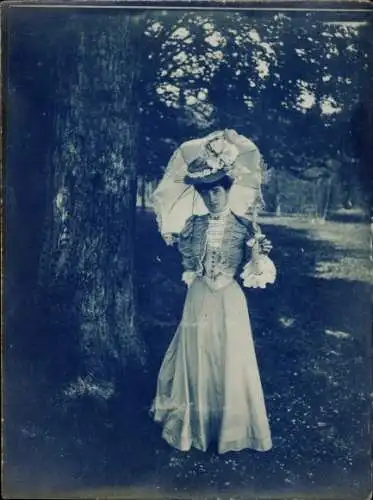 Foto Elegante Dame mit Sonnenschirm an einem Baum, Portrait