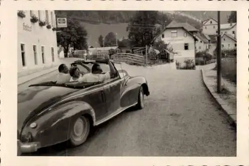 Foto Ak Österreich, Ortspartie, Gasthof, Personen im Automobil winken bei der Abfahrt