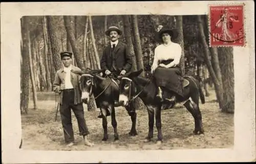 Foto Ak Paar beim Ritt auf einem Esel, Waldpartie, Eselsführer