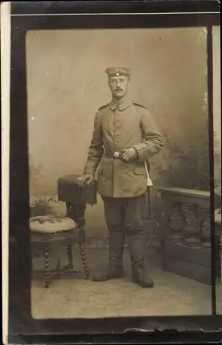 Foto Ak Deutscher Soldat in Uniform, Standportrait, Sessel