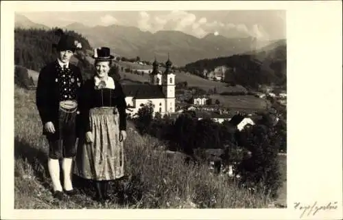 Ak Hopfgarten im Brixental in Tirol, Mann und Frau in Tracht auf Wiese