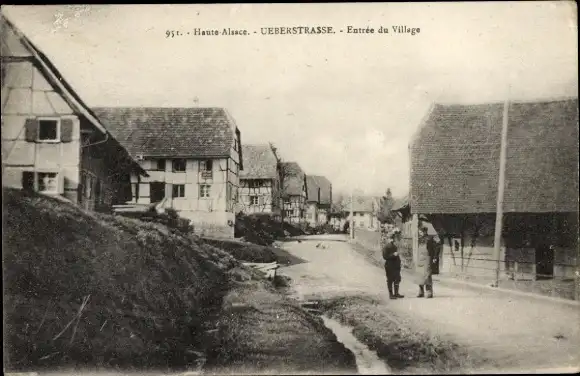 Ak Ueberstrass Elsass Haut Rhin, Entrée du Village, maisons, passants