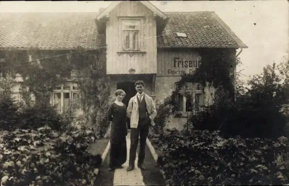 Foto Ak Bad Harzburg am Harz, Mann und Frau im Garten vor einem Wohnhaus, Friseur