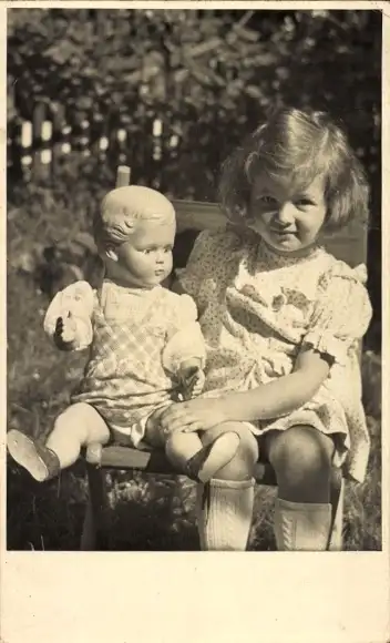 Foto Ak Mädchen mit Puppe auf einem Stuhl, Portrait