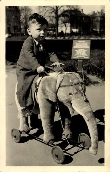 Foto Ak Junge auf einem Plüschelefant auf Rollen, Portrait 1951