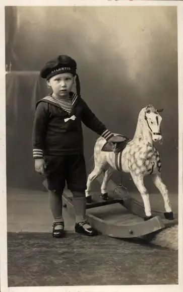 Foto Ak Junge im Matrosenanzug mit einem Schaukelpferd, Portrait