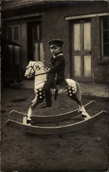 Foto Ak Junge in Uniform auf einem Schaukelpferd, Portrait