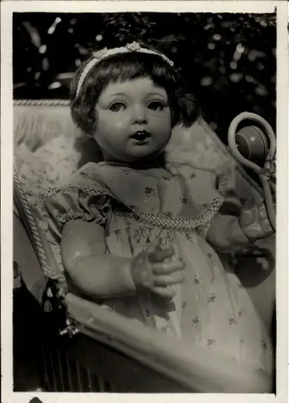 Foto Puppe mit Rassel in einem Puppenwagen