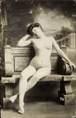 Foto Ak Frauenakt, nackte Frau sitzt auf einer Steinbank, Busen