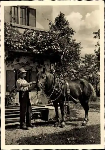 Foto Ak Mann mit Pferd vor einem Haus