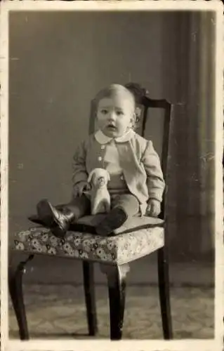 Foto Ak Kind und ein Spielzeug, Portrait, Stuhl