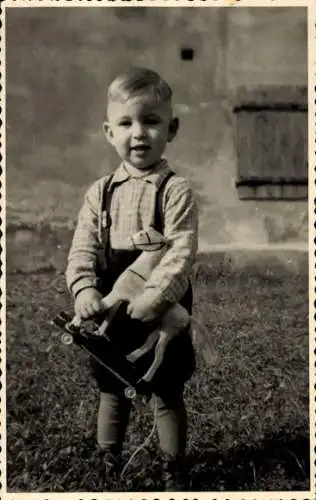 Foto Ak Junge mit Spielzeug, Portrait, Pferd