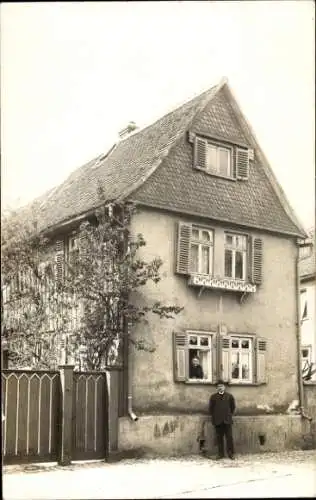 Foto Ak Assenheim Niddatal Hessen, Mann vor einem Wohnhaus, Frau am Fenster