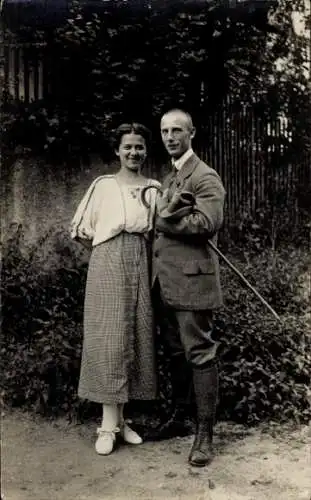 Foto Ak Mann mit Gehstock und Frau in einem Garten, Portrait