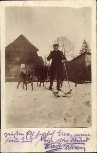 Foto Ak Skiläufer, Hund, Wohnhäuser