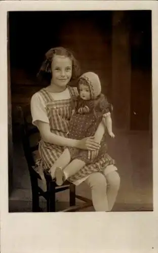 Foto Ak Mädchen und Puppe, Portrait, Stuhl