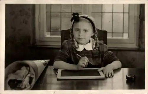 Foto Ak Glückwunsch Einschulung, Mädchen am Tisch mit Schiefertafel und Zuckertüte