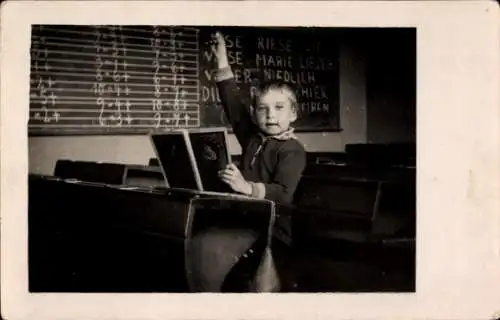 Foto Junge in einem Klassenzimmer meldet sich, Tafel