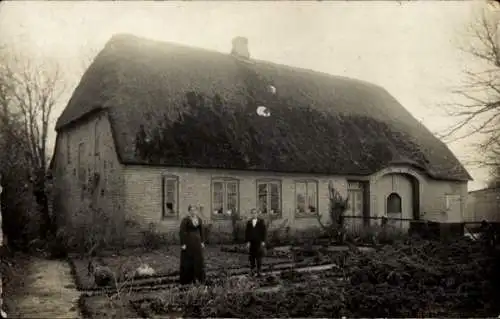 Foto Ak Hüsby Schleswig Holstein, Frau und Junge im Garten vor einem Wohnhaus