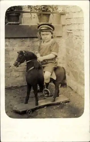 Foto Ak Kind auf Schaukelpferd, Portrait, Spielzeug