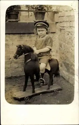 Foto Ak Kind auf Schaukelpferd, Portrait, Spielzeug