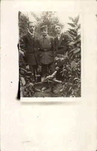 Foto Ak Soldat in Uniform und zwei junge Männer in Anzügen, Portrait