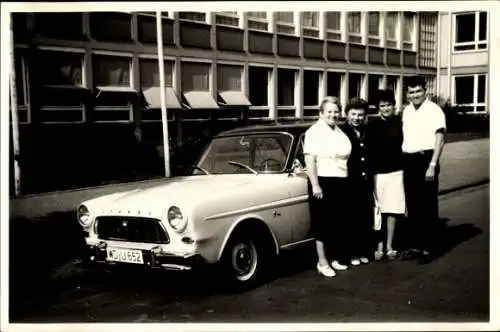 Foto Männer und Frauen vor einem Automobil