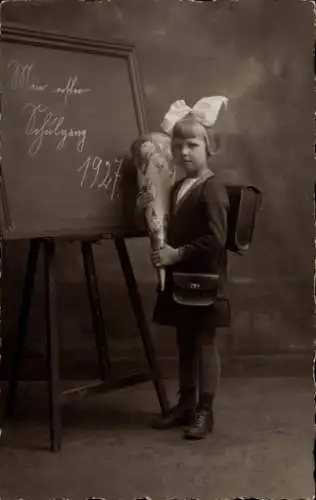 Foto Ak Glückwunsch Einschulung, Mädchen mit Zuckertüte und Schulranzen vor einer Tafel 1927