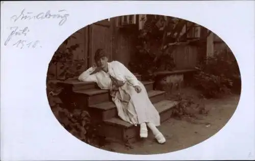 Foto Ak Junge Frau auf einer Treppe sitzend, Dünaburg Juli 1918