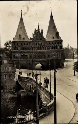 Ak Lübeck in Schleswig Holstein, Holstentor, Gesamtansicht, Brücke, Uferpartie, Passanten