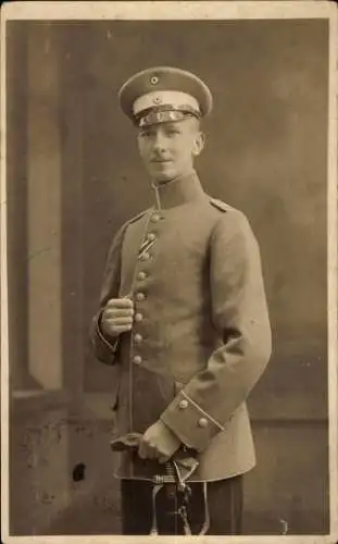 Foto Ak Deutscher Soldat in Uniform, Standportrait, Schirmmütze, Säbel