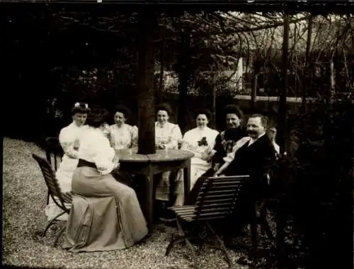 Foto Gruppenaufnahme von einem Mann und Frauen in einem Garten