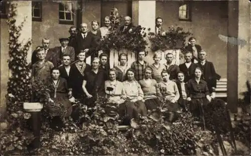 Foto Ak Männer und Frauen vor einem Haus, Gruppenaufnahme