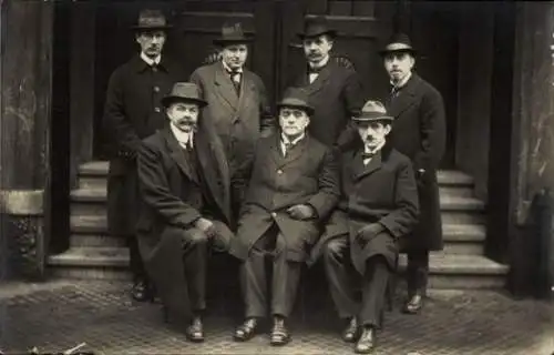 Foto Ak Männer in Mänteln und mit Hüten vor einem Haus, 1920