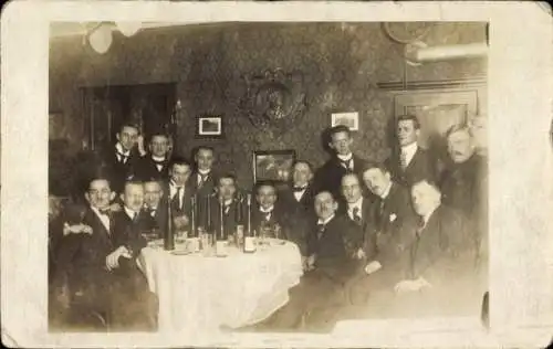 Foto Ak Männer in einem Gasthaus, Weinflaschen, Gruppenaufnahme
