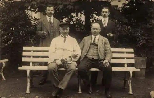 Foto Ak Vier Männer auf und hinter einer Bank