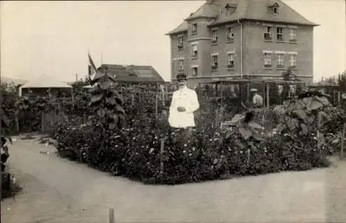 Foto Ak Friedberg in Hessen, Garten, Sonnenblumen, Mann in Uniform