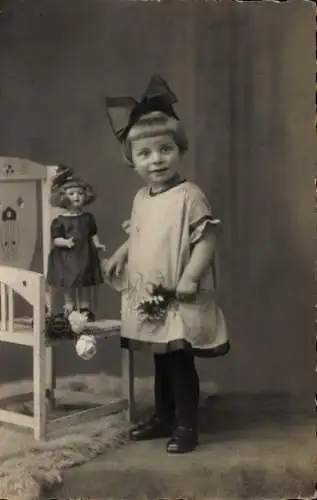 Foto Ak Mädchen mit Puppe, Portrait, Stuhl, Spielzeug