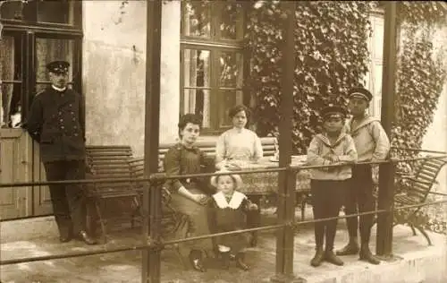 Foto Ak Flensburg, Familie auf einer Veranda, Mann in Uniform, Jungen in Matrosenhemden